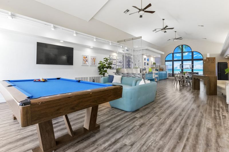 Clubhouse game room with a pool table, couches, and TV