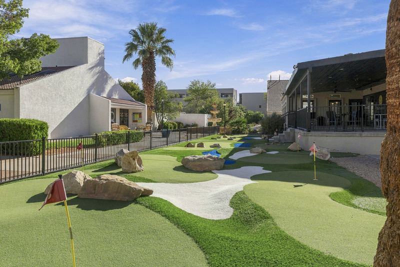 Putting green with sand traps and flags beside the clubhouse